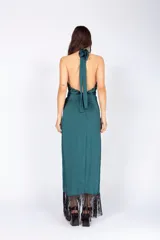 Vestido largo de seda lavada color azul marino, con escote halter cruzado, abertura en la falda y flecos en el ruedo.