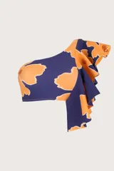 Top de bikini asimétrico con un solo hombro, estampado con flores naranjas sobre fondo azul marino y volado grande en el hombro.