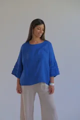 Blusa azul francia de lino italiano con escote redondo y mangas 3/4 con volados.