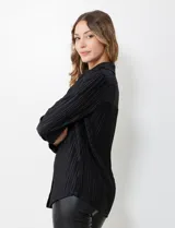 Camisa negra de satén plisado con cuello con solapa y abertura central con botones.