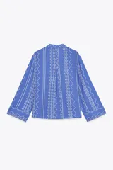 Camisa azul con bordados blancos, de cuello redondo con escote pico y manga larga.