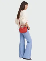 Bandolera Longchamp modelo Le Pliage XS, color rojo con estampado de letras en relieve.