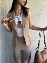 Chaleco sastrero color tostado con rayas verticales finas, escote en V y cierre frontal con botones.