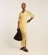 Vestido midi color amarillo pálido con efecto crochet, cuello polo, manga corta y abertura lateral. Confeccionado en algodón BCI más sostenible.