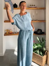 Pantalón ancho de tiro alto, color beige claro con textura, confeccionado en tela crepé. Presenta cintura elástica con cordón ajustable.