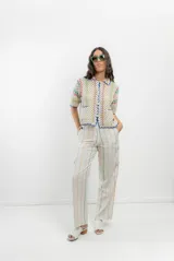 Saco tejido a crochet con diseño a rayas multicolores y detalles en azul.