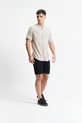 Camisa blanca de manga corta con cuello mao y doblez en las mangas.