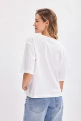 Remera blanca de corte amplio con estampado de Cenicienta y la frase 'The Right Shoe Makes the Difference'.