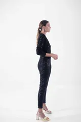 Mono largo negro con lentejuelas, escote en V cruzado, mangas largas y corte ajustado.