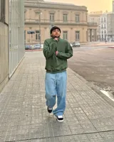 Buzo verde militar de felpa con frisa gruesa, corte boxy, medio cierre con cremallera y estampado minimalista con la frase "The Wise Club Exclusive Members".