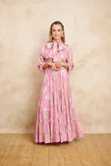 Vestido largo color rosa con estampado dorado, cuello con lazo y mangas largas. Incluye cinturón dorado.