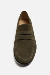 Mocasín color marrón de cuero con acabado serraje, antifaz, horma redonda y suela con ligero tacón.