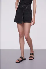 Short de jean negro con corte asimétrico y cierre con botón.