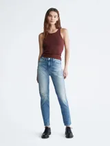 Jean de denim celeste con efecto desgastado y roturas, de corte mom, tiro alto y cinco bolsillos.