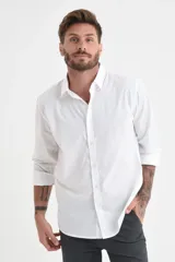 Camisa blanca de manga larga con cuello clásico y cierre frontal con botones.