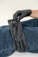 Guantes de cuero negro con costuras decorativas en los dedos.