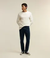 Pantalón de jean azul oscuro, corte slim, con trabillas en la cintura y bolsillos.