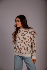 Sweater de punto color crudo con estampado animal print marrón.