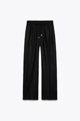 Pantalón negro de lino, de tiro alto con cintura elástica ajustable con cordones, bolsillos delanteros y pernera recta.