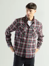 Camisa de franela con diseño a cuadros en tonos negro, rojo y blanco, con dos bolsillos frontales.