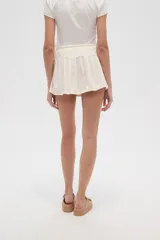 Minifalda plisada color crema con cintura elastizada y cierre frontal con botones de madera.