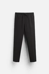 Pantalón negro de corte regular fit, con cintura elástica ajustable con cordón, bolsillos laterales y bolsillos de vivo en la parte trasera.