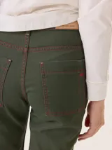 Jean recto de gabardina color marrón/camel, con pespuntes contrastantes en color negro. Presenta un detalle de atraque rojo en el bolsillo trasero.