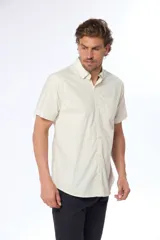 Camisa azul marino lisa de manga corta con cuello abotonado, cierre frontal con botones y bolsillo en el pecho. Confeccionada en algodón.