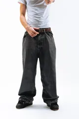 Pantalón de jean azul desgastado, corte mega baggy, con bordado dorado en el bolsillo trasero y botones personalizados.