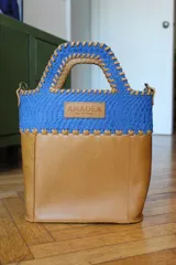 Bolso matero de cuero color miel con detalles en azul, con correa de cuero desmontable.