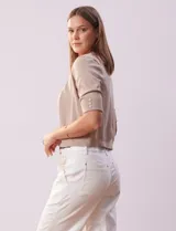 Bolero tejido color beige, marca Ninety, de manga corta con apliques de botones en los puños.