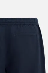 Pantalón azul marino de corte amplio, confeccionado en tejido de mezcla de algodón y lino. Cuenta con cintura elástica ajustable con cordón, bolsillos frontales y bolsillos traseros de vivo.