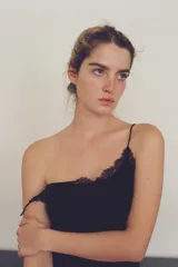 Top negro con tirantes finos, escote redondo y detalle de encaje en el busto.