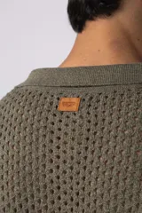 Camisa negra tejida de manga corta, con calado aireado, cuello tipo bowling y botones al tono. Diseño de corte relajado.