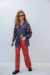 Pantalón color rojo de gabardina elastizada, con diseño floral en tonos cálidos.