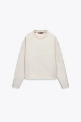 Sweater color crudo de cuello redondo y manga larga.