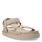 Sandalias planas color beige con tiras anchas acolchadas y ajuste con velcro en el tobillo.