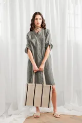 Túnica manga larga color verde militar de lino, con cuello mao, bolsillos frontales y cierre con botones.