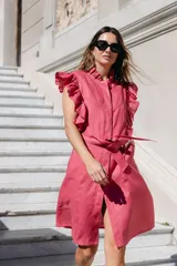 Vestido camisero celeste con cuello mao y volados en los hombros. Tiene cierre frontal con botones y lazo removible en la cintura.