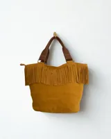 Cartera de cuero color mostaza con flecos estilo boho chic. Con cierre, interior forrado, dos bolsillos internos y portallave.