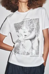 Camiseta blanca de corte recto y manga corta, con estampado frontal de una fotografía en blanco y negro y texto "Amsterdam 74".