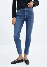 Jeans mom fit de tiro alto, color azul denim, con cinco bolsillos, cierre de cremallera y botón.
