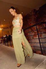 Pollera larga color verde oliva, con base fruncida, transparencias y pequeños volados verticales.