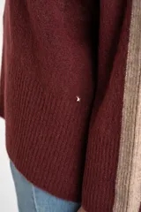 Sweater negro de tejido grueso con cuello alto acanalado. Presenta una franja decorativa en las mangas y el cuello en hilo marrón con brillo (lurex).