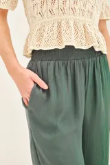 Pantalón palazzo negro de tiro alto con cintura elastizada y bolsillos diagonales.