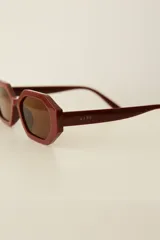 Lentes de sol con marco hexagonal de policarbonato en color bordó y cristales oscuros. Cuentan con protección UV400.