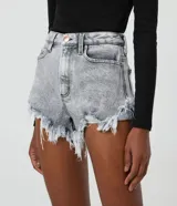 Short hot pants de jeans color gris claro con cintura alta, cierre con cremallera y botón, bolsillos y terminación deshilachada.