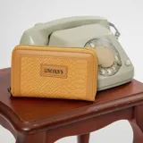 Billetera mediana color beige con textura croco, cierre alrededor y logo Lincoln's.