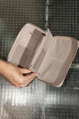 Billetera negra de cuero con cierre de cremallera, múltiples ranuras para tarjetas, compartimento para billetes y monedero con cremallera.