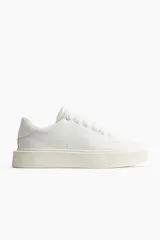 Championes blancos de cuero con cordones y suela gruesa.